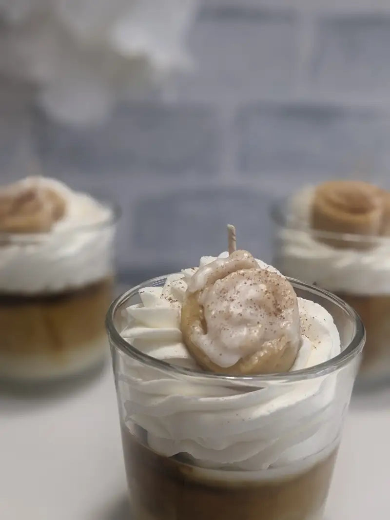 un dessert dans un verre avec de la crème fouettée et de la cannelle